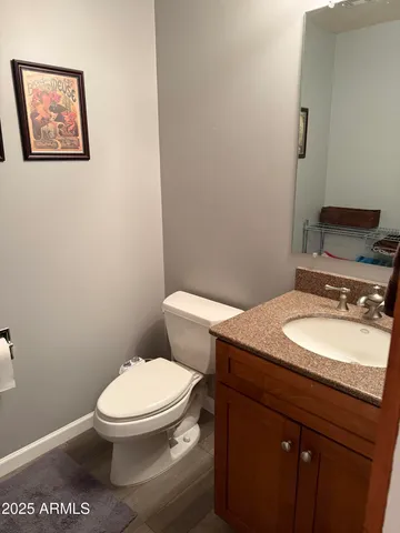 a bathroom with a granite countertop toilet and a sink