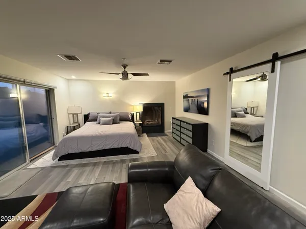 a spacious bedroom with a bed and wooden floor