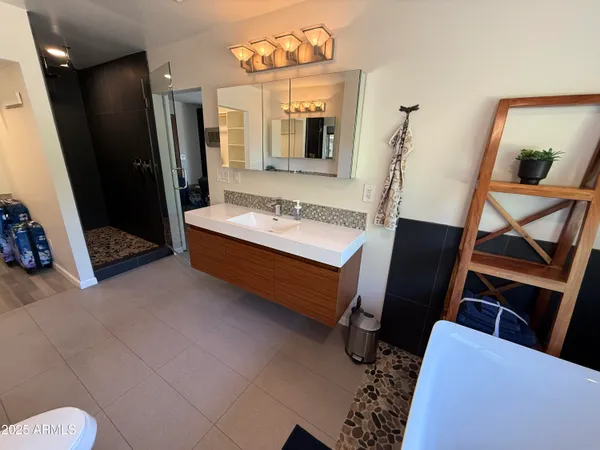 a bathroom with a sink mirror and a toilet