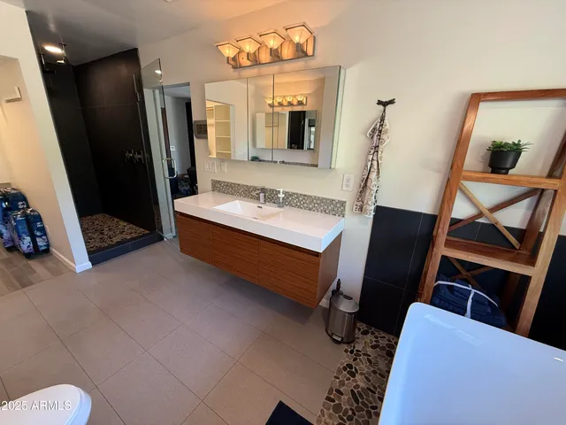 a bathroom with a sink mirror and a toilet