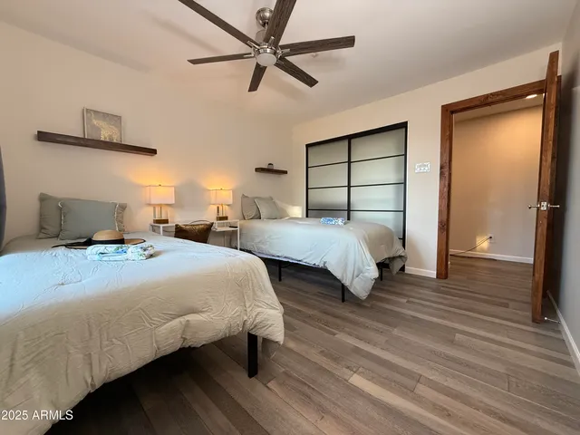a bedroom with two beds and a ceiling fan