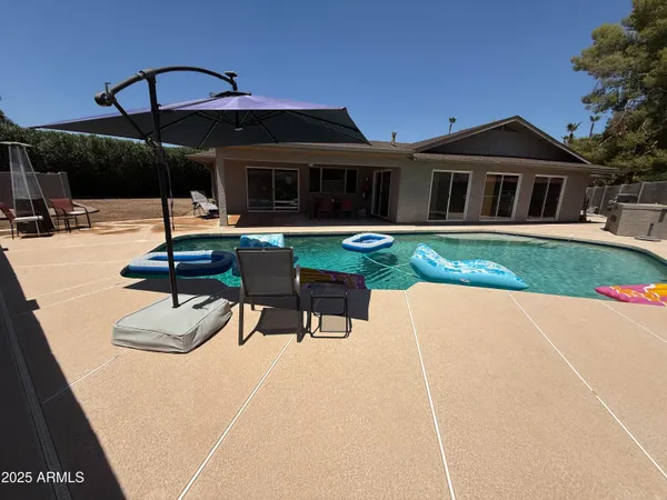 a view of a house with backyard and sitting area