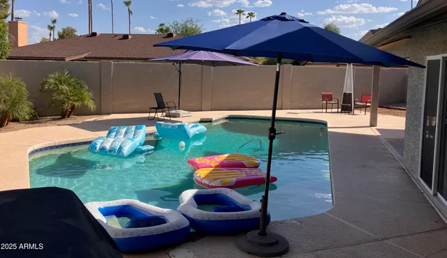 a backyard of a house with table and chairs