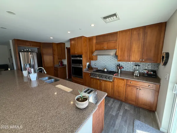 a kitchen with stainless steel appliances granite countertop a refrigerator sink and stove