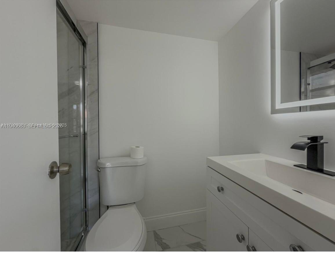 7610 Stirling Road, Unit 207F Davie, FL 33024 - Photo 12 of 22 a bathroom with a sink a toilet and a mirror
