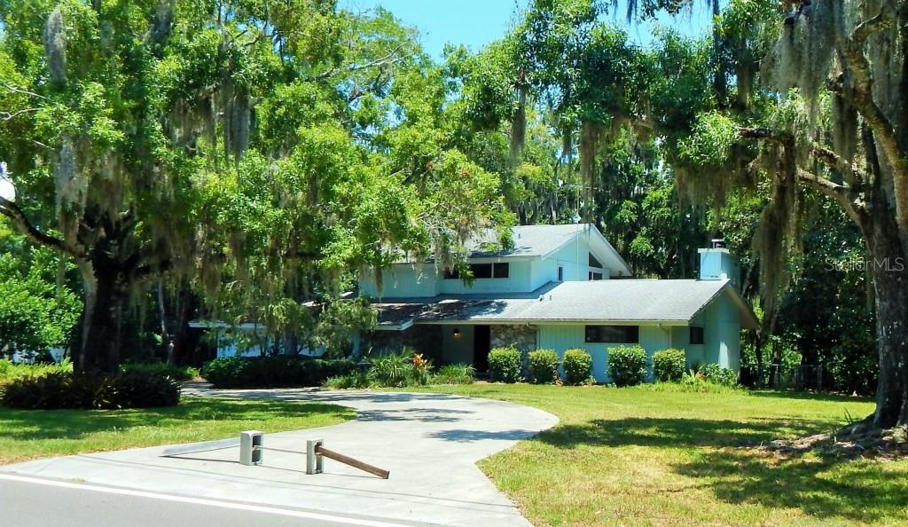 6014 River Road New Port Richey, FL 34652 - Photo 1 of 1 a view of a white house with a yard plants and large tree