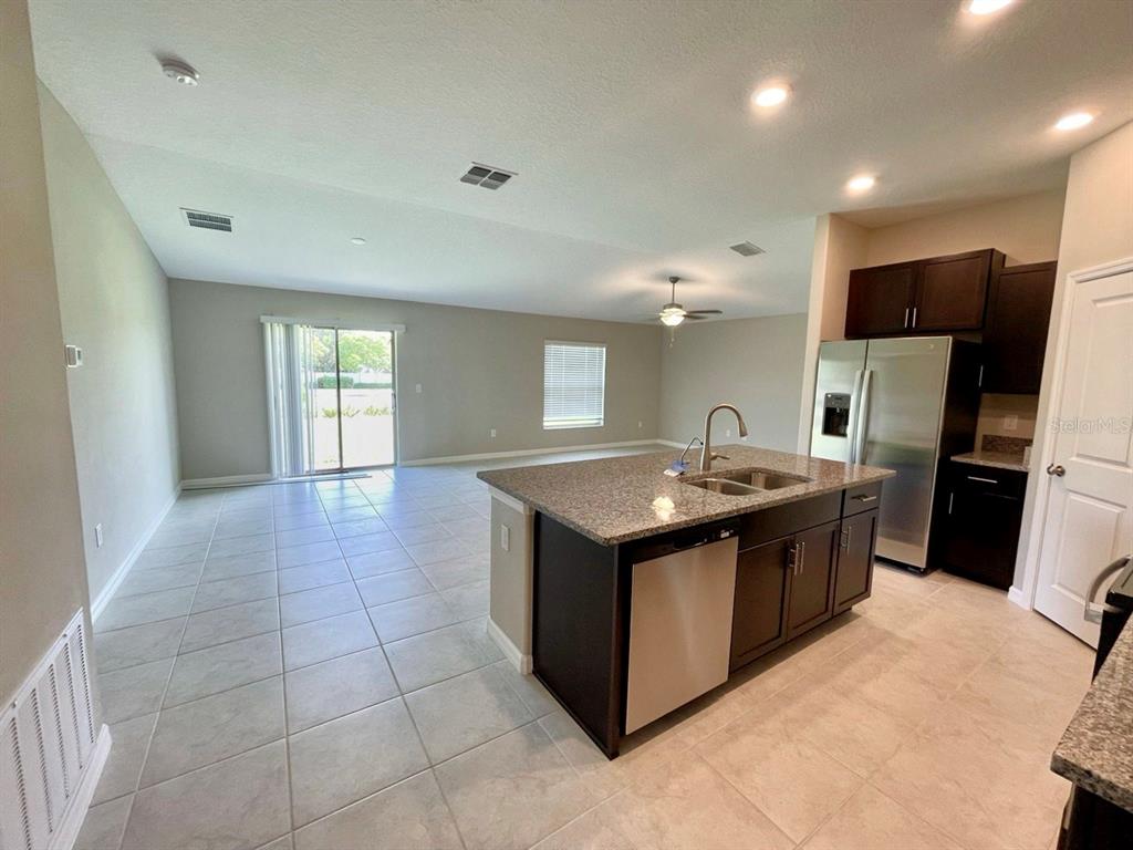 869 Anchor Bend Drive Ruskin, FL 33570 - Photo 2 of 23 a kitchen with stainless steel appliances granite countertop a sink and a refrigerator