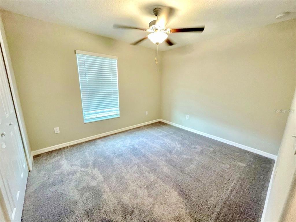 869 Anchor Bend Drive Ruskin, FL 33570 - Photo 8 of 23 an empty room with windows and fan