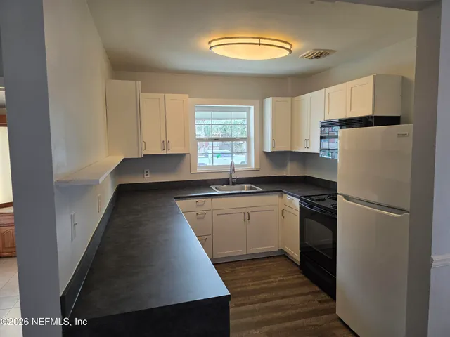 a kitchen with a refrigerator and a sink