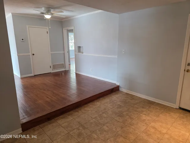 an empty room with wooden floor and staircase