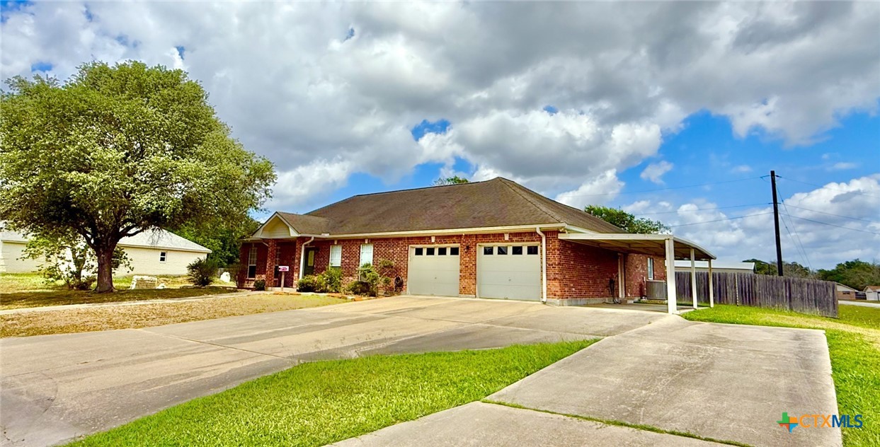 415 South Trinity Street Edna, TX 77957 - Photo 3 of 46 a view of a white house with a big yard and large trees