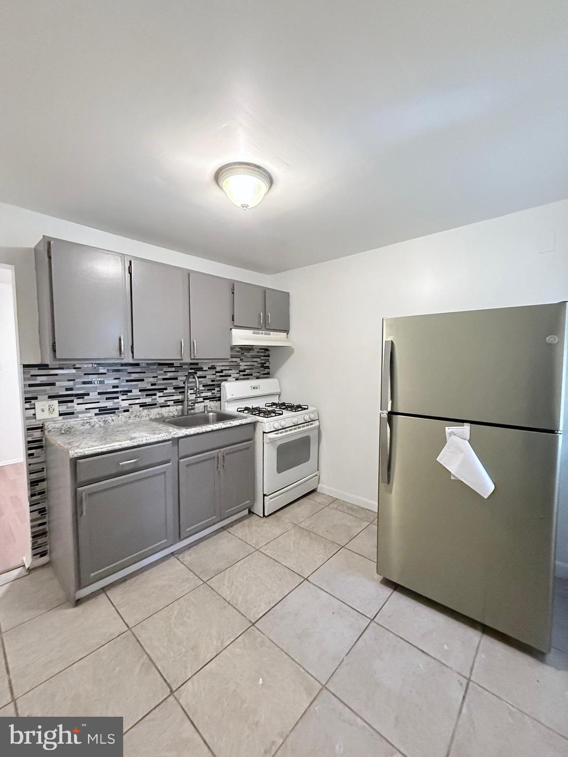 1820 West Fayette Street, Unit 1 Baltimore, MD 21223 - Photo 11 of 19 a kitchen with cabinets and white appliances
