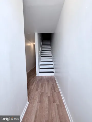 a view of a hallway with wooden floor and entryway