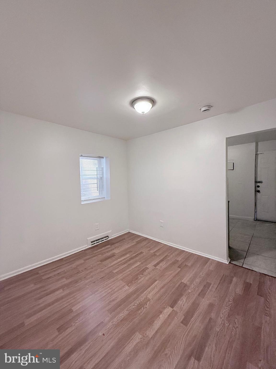1820 West Fayette Street, Unit 1 Baltimore, MD 21223 - Photo 6 of 19 an empty room with wooden floor and windows
