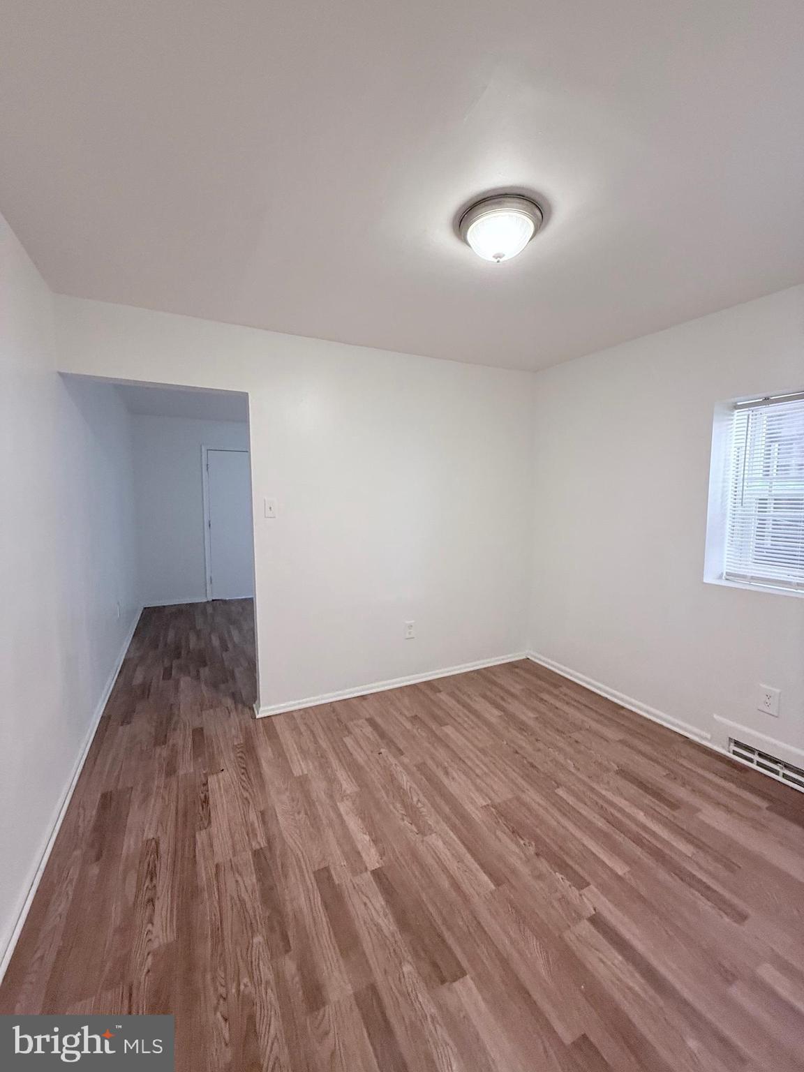 1820 West Fayette Street, Unit 1 Baltimore, MD 21223 - Photo 9 of 19 an empty room with wooden floor and windows