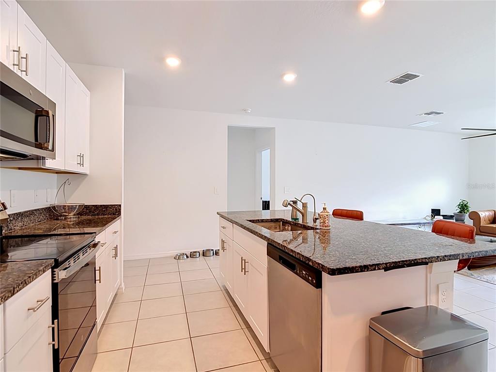 1633 Red Loop Lakeland, FL 33801 - Photo 7 of 60 a kitchen with stainless steel appliances granite countertop a stove a sink and a microwave