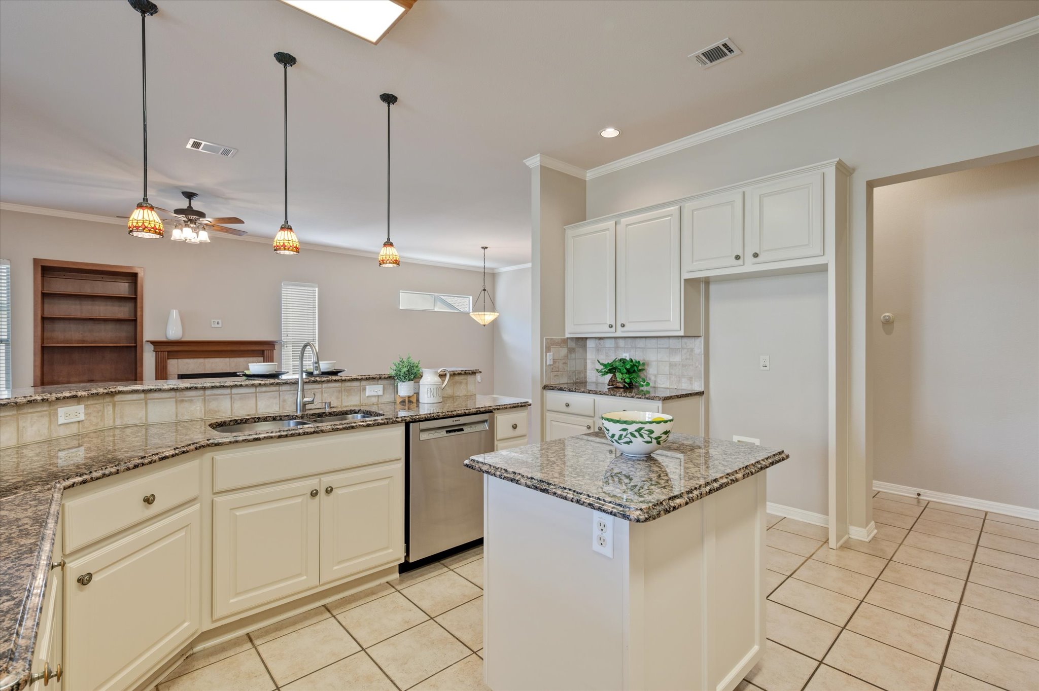 114 Whippoorwill Way Georgetown, TX 78633 - Photo 15 of 37 a kitchen with kitchen island granite countertop a sink stove and white cabinets