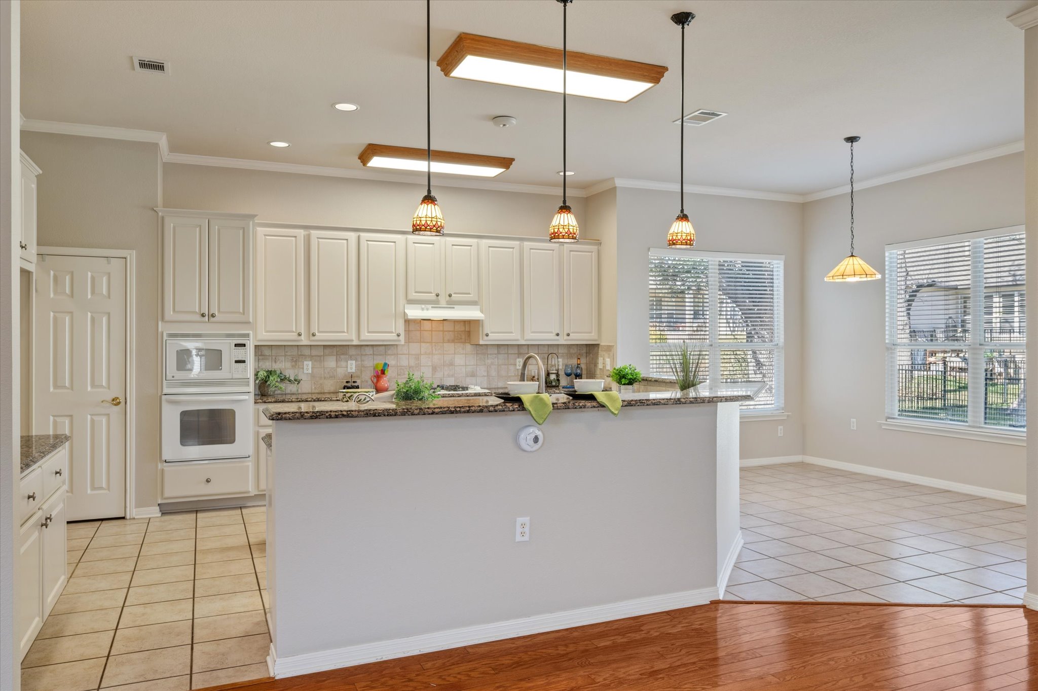 114 Whippoorwill Way Georgetown, TX 78633 - Photo 29 of 37 a kitchen with stainless steel appliances granite countertop a sink a stove and white cabinets with wooden floor