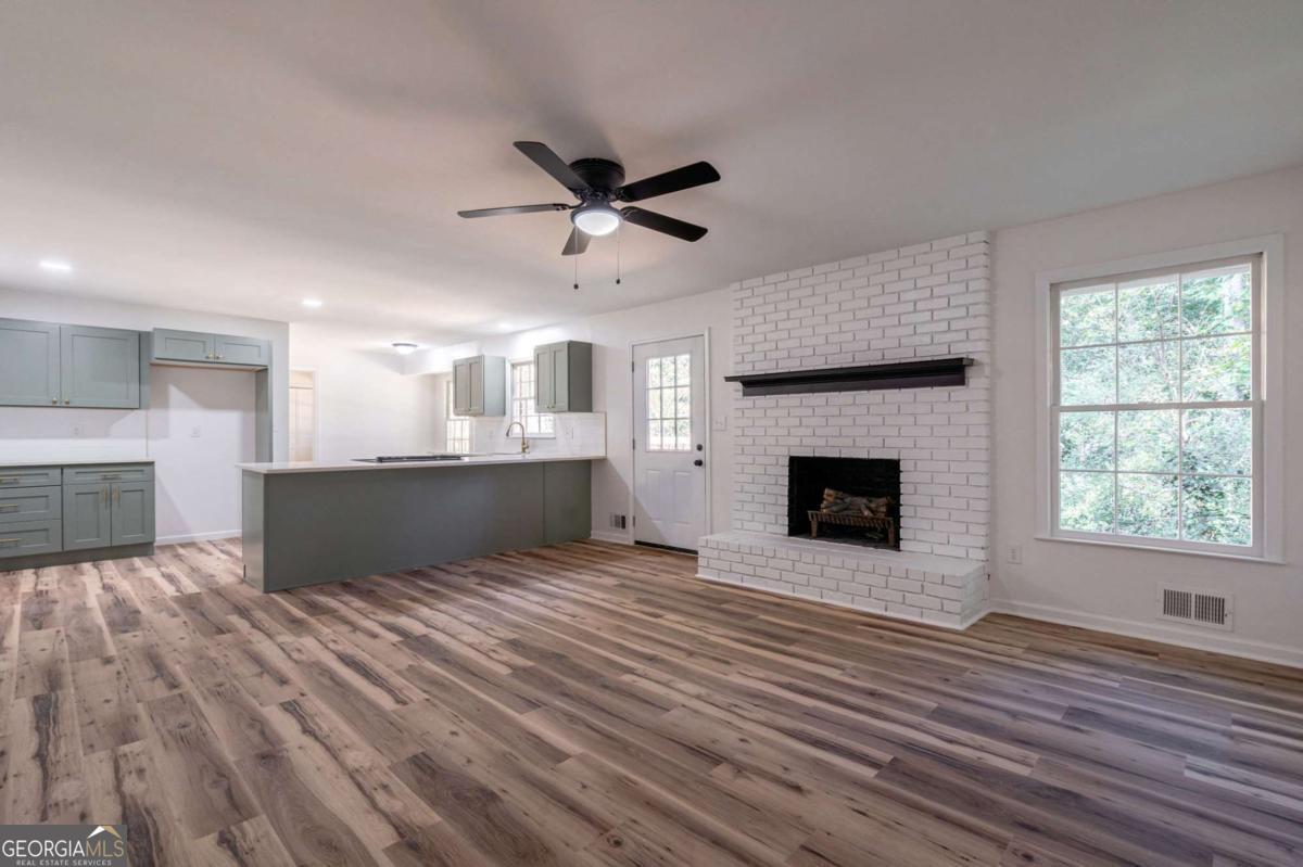 400 Sandstone Drive Athens, GA 30605 - Photo 3 of 41 a view of a kitchen and an empty room with wooden floor a fireplace
