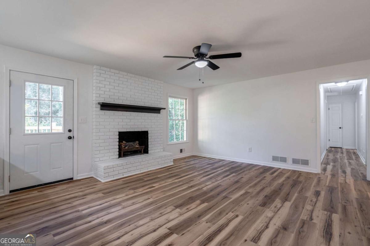 400 Sandstone Drive Athens, GA 30605 - Photo 4 of 41 a view of empty room with wooden floor and fireplace