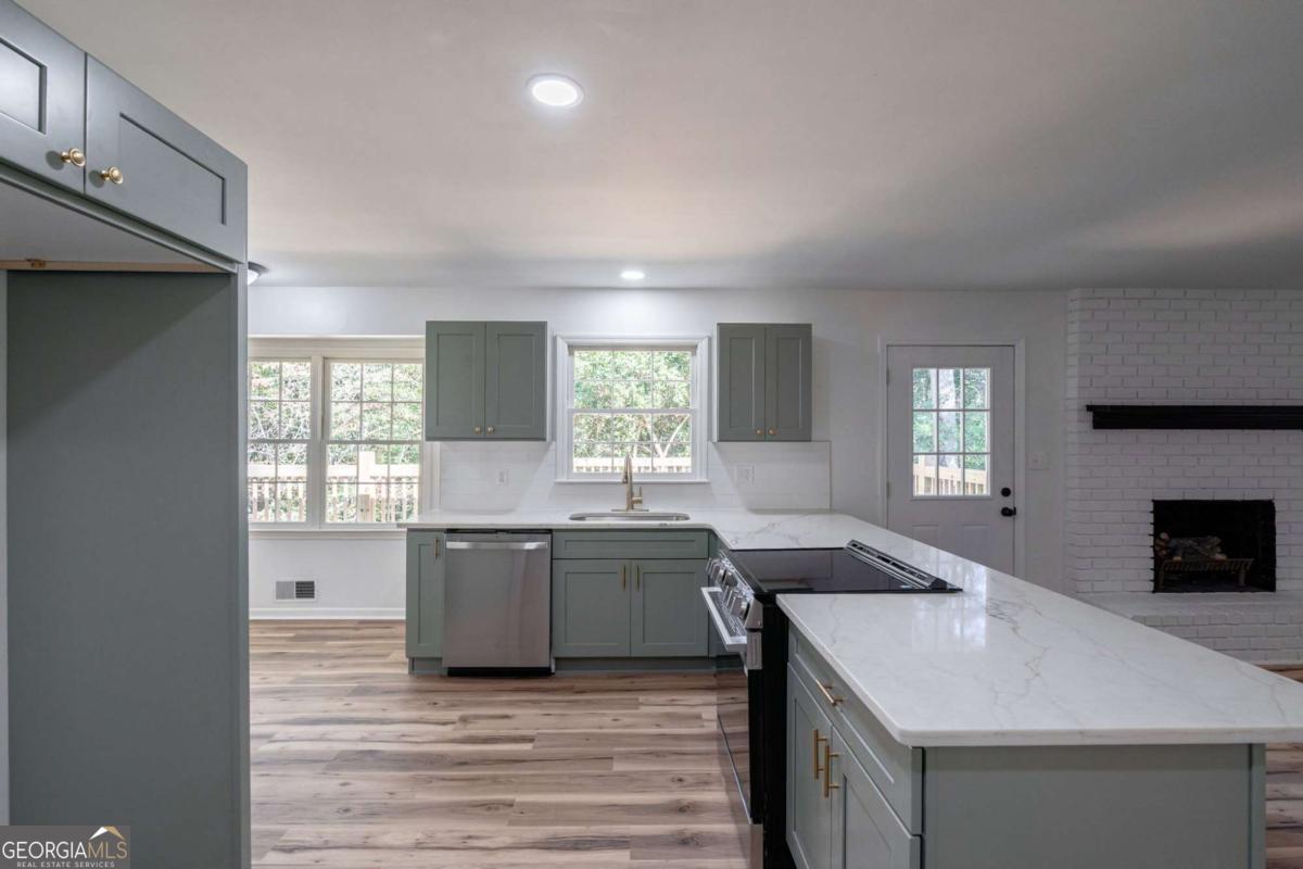 400 Sandstone Drive Athens, GA 30605 - Photo 6 of 41 a kitchen with granite countertop a sink stove and cabinets