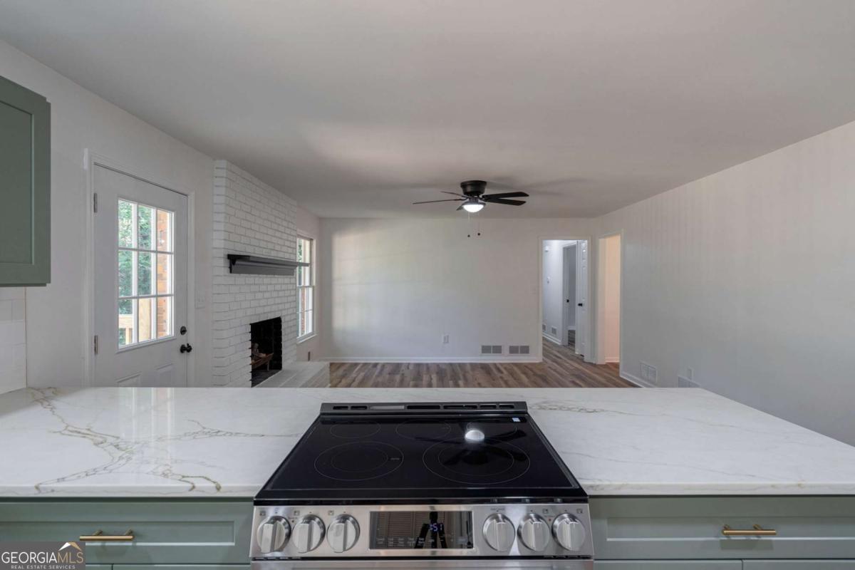 400 Sandstone Drive Athens, GA 30605 - Photo 8 of 41 a kitchen with granite countertop a stove and white cabinets