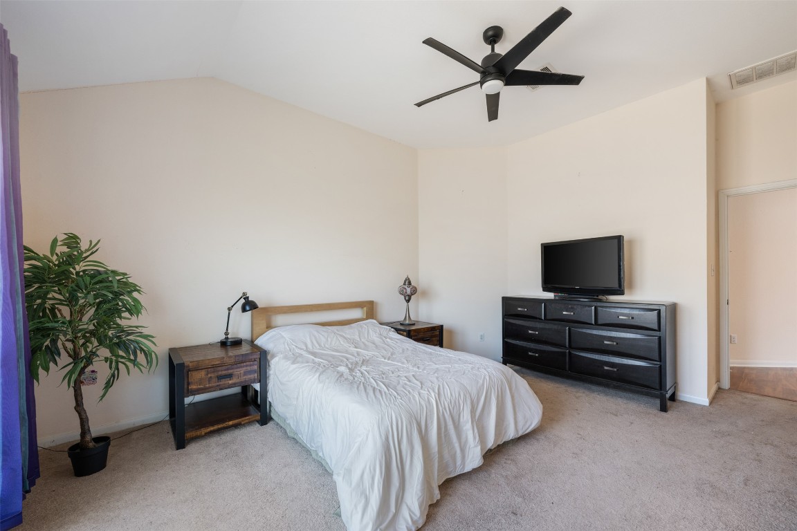 221 Stone Crest Boulevard Buda, TX 78610 - Photo 19 of 33 a bedroom with a bed and a television