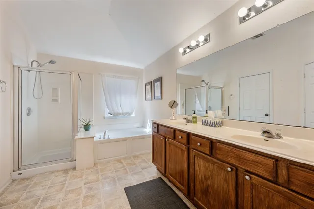 a spacious bathroom with a shower sink and mirror
