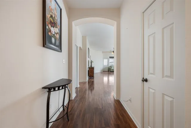 a view of a hallway with wooden floor and staircase