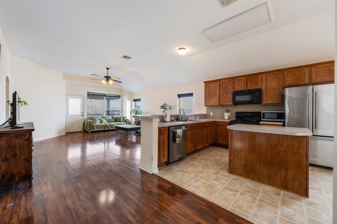 221 Stone Crest Boulevard Buda, TX 78610 - Photo 33 of 33 a kitchen with stainless steel appliances wooden floors and wooden cabinets