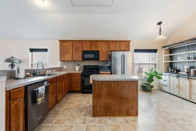 a kitchen with stainless steel appliances wooden floors and wooden cabinets
