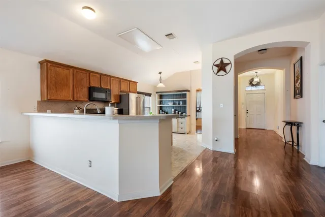 a large kitchen with stainless steel appliances a stove a sink dishwasher a refrigerator a oven and a refrigerator