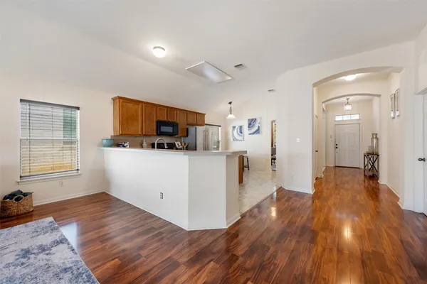 a kitchen with stainless steel appliances wooden floors and wooden cabinets