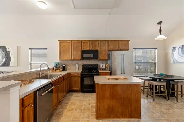 a kitchen with stainless steel appliances granite countertop a refrigerator stove and sink