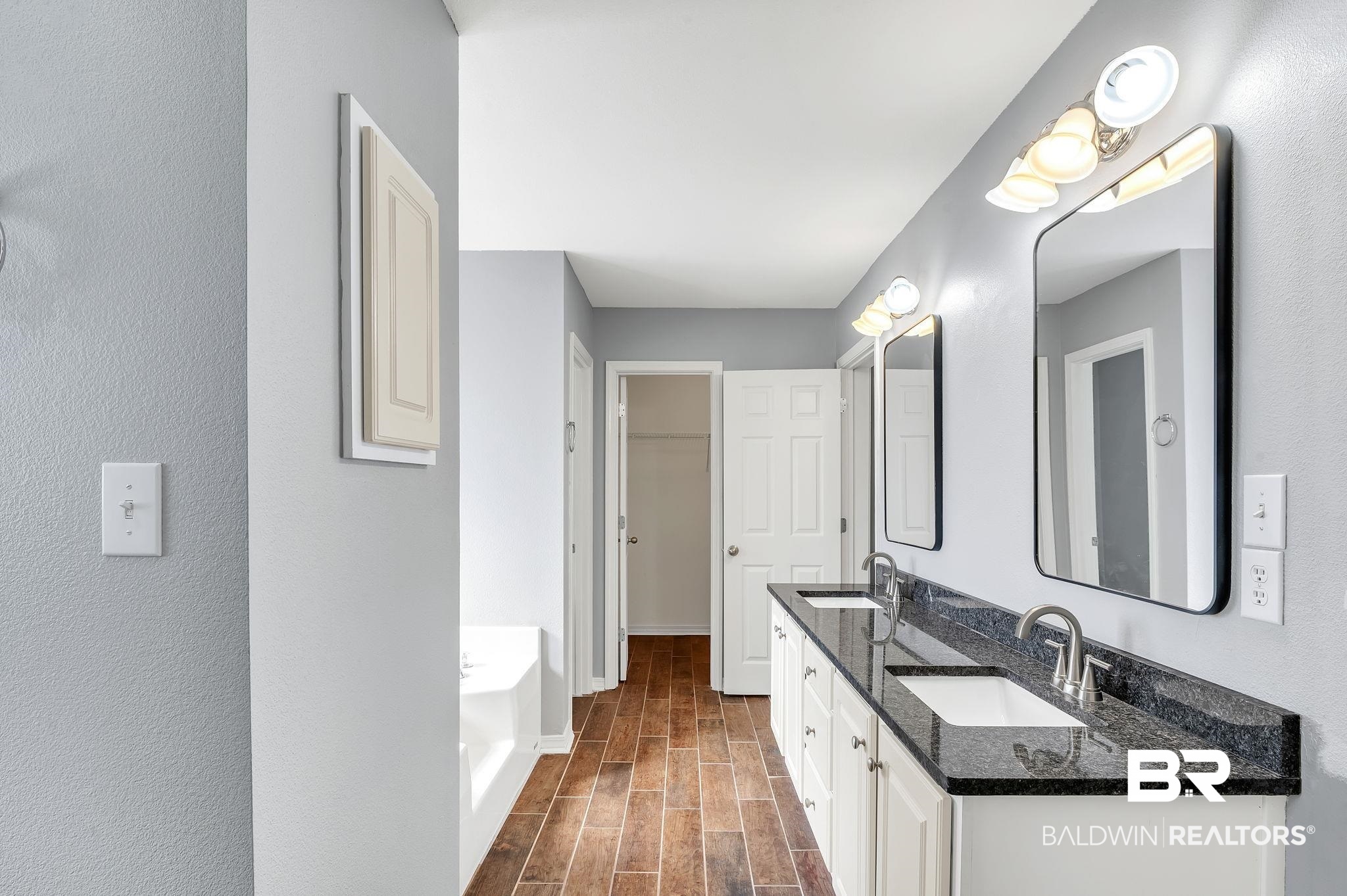 16444 Hamlet Lane Foley, AL 36535 - Photo 26 of 49 Full bathroom featuring a bath, double vanity, a sink, and wood finished floors