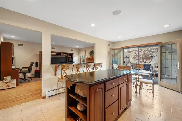 a kitchen with stainless steel appliances granite countertop a sink counter and chairs