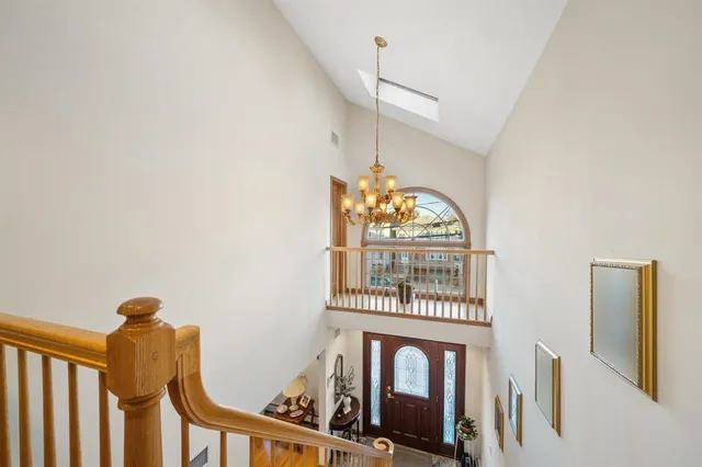 a spacious bedroom with a bed and a chandelier