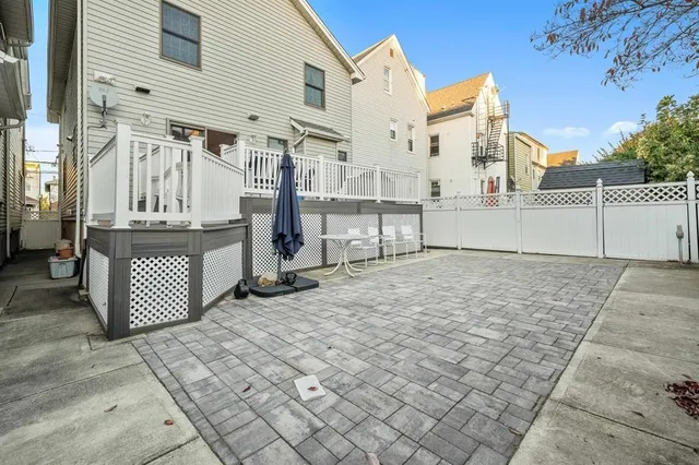 a view of a house with a small yard and wooden fence