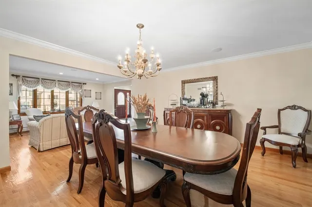 a dining room with furniture a chandelier and wooden floor