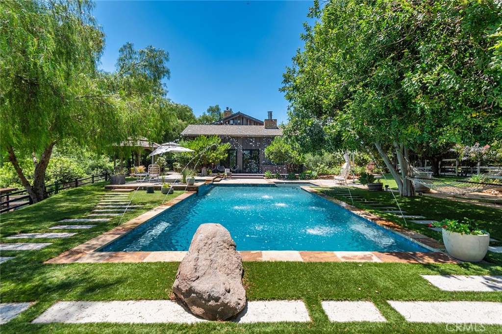 5207 Saddle Creek Road Hidden Hills, CA 91302 - Photo 37 of 54 a view of a swimming pool with a garden