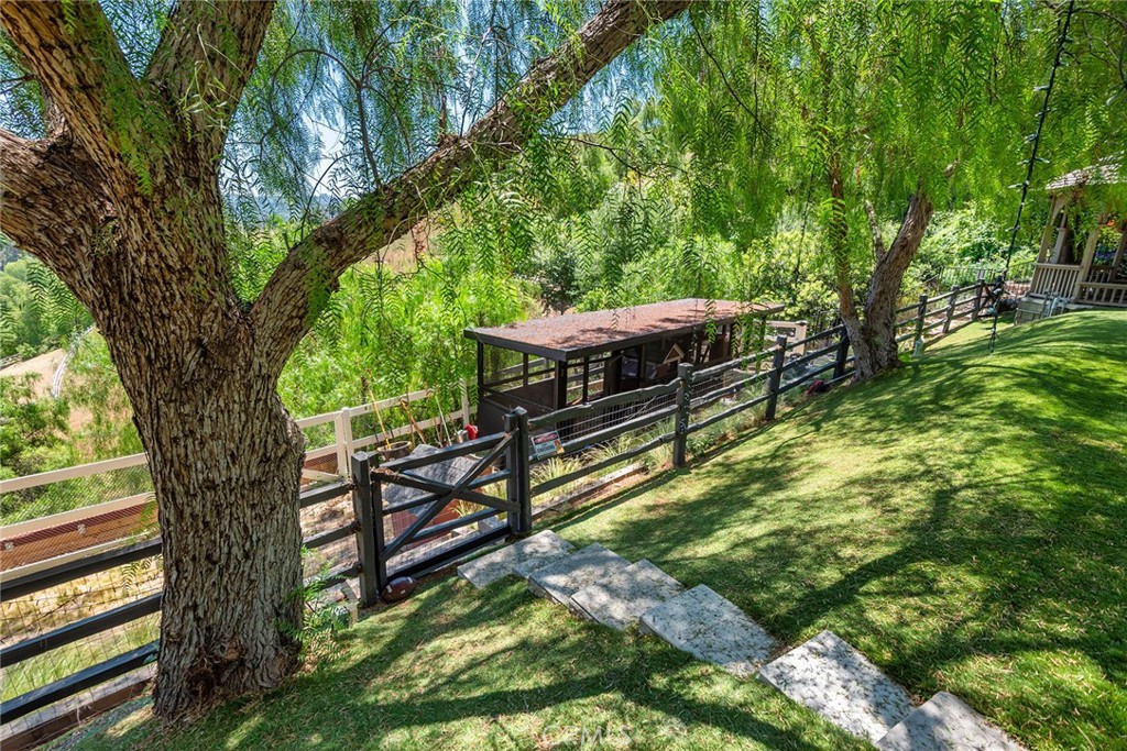 5207 Saddle Creek Road Hidden Hills, CA 91302 - Photo 45 of 54 a view of a backyard with wooden fence and a large tree
