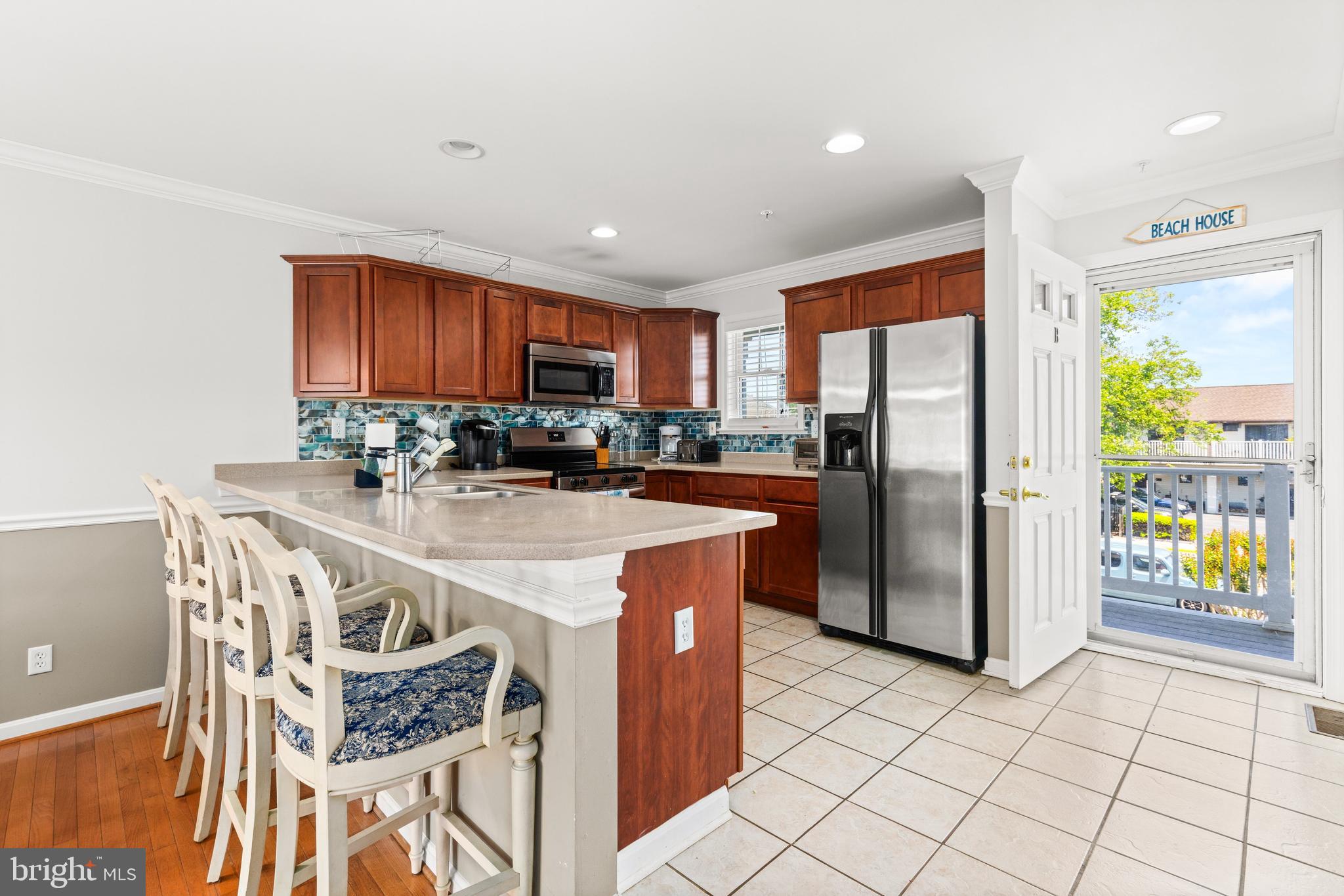 617 Salt Spray Road, Unit B Ocean City, MD 21842 - Photo 47 of 72 a kitchen with stainless steel appliances granite countertop a refrigerator a sink a stove a dining table and chairs