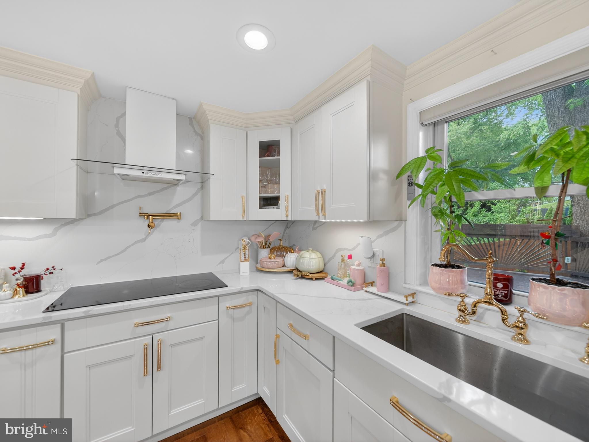 13427 Delaney Road Woodbridge, VA 22193 - Photo 29 of 57 a kitchen with a sink dishwasher a stove and white cabinets with wooden floor