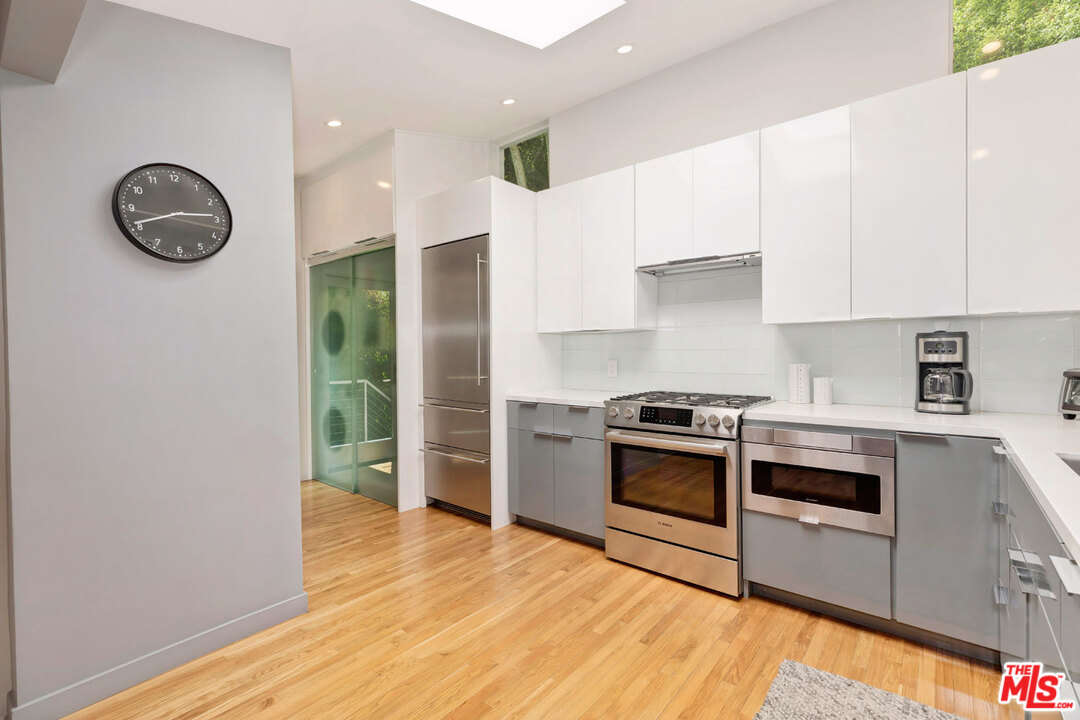 9831 Easton Drive Beverly Hills, CA 90210 - Photo 11 of 27 a kitchen with a stove a sink and a refrigerator