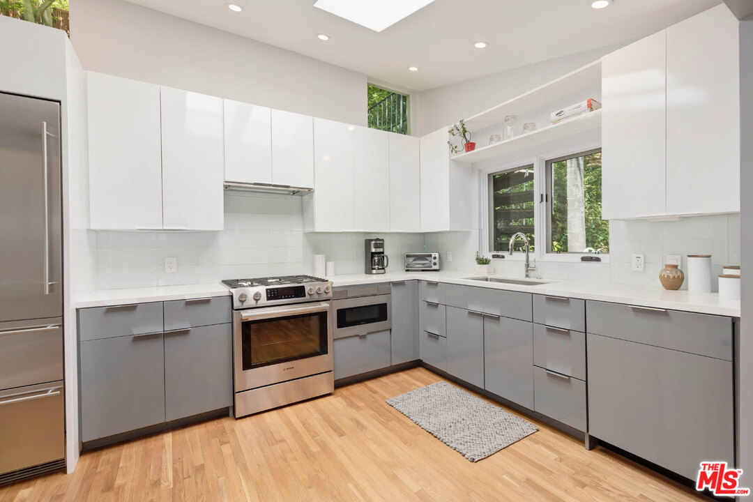 9831 Easton Drive Beverly Hills, CA 90210 - Photo 9 of 27 a kitchen with a stove sink and cabinets