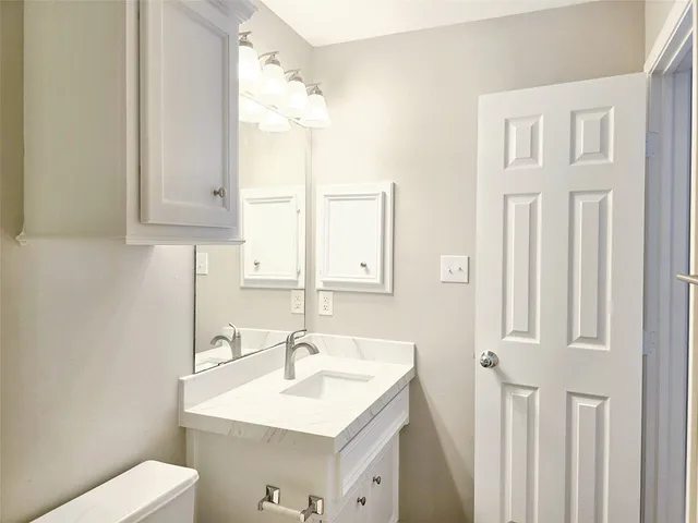 a bathroom with a sink a toilet and a mirror