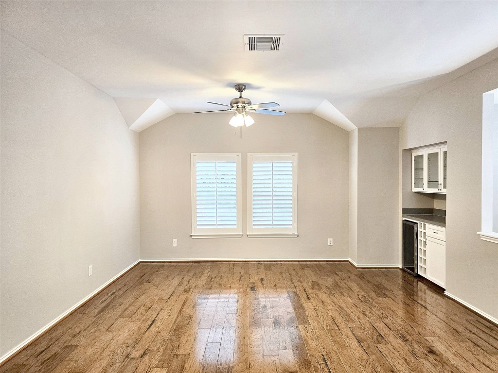 2211 Runnels Street Houston, TX 77003 - Photo 4 of 17 an empty room with wooden floor chandelier fan and windows