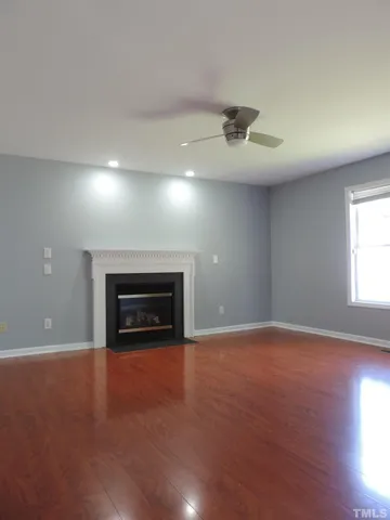 a view of an empty room with a fireplace and a window