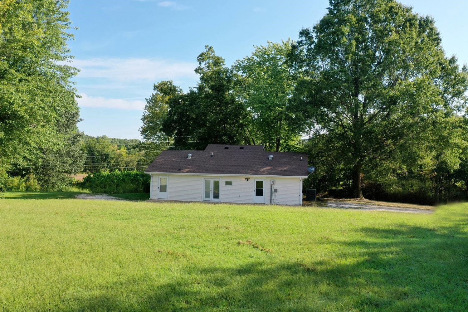 707 Baker Road Martin, TN 38237 - Photo 29 of 32 a house that is sitting in the grass with tress in the background