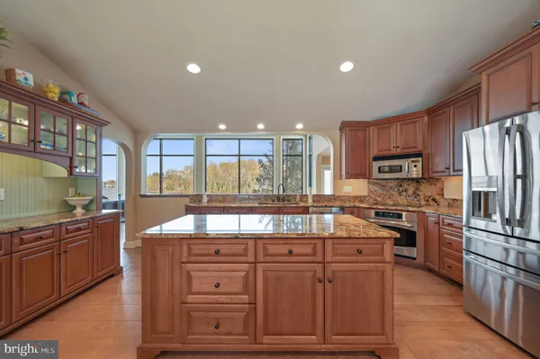 a kitchen with stainless steel appliances granite countertop lots of counter top space and wooden floor
